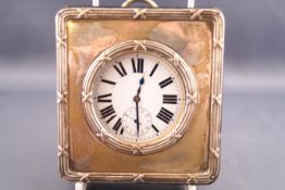 A chromed giant pocket watch with white enamel Roman dial in a leather strut frame