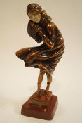 An Art Deco style figure of a lady with muff, on marble plinth,