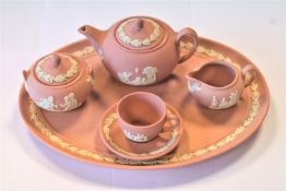 A Wedgwood jasperware finish pink miniature tea set, comprising a tea pot, covered sugar, milk jug,