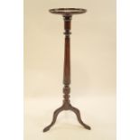 A mahogany torchere, the round top with beaded moulding,