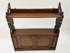 A set of six Victorian mahogany hanging wall shelves with two panelled doors,