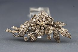 A white metal diamond set floral tremblant brooch