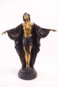 A brass statue of a dancing girl, standing semi clad in a draped open chemise,
