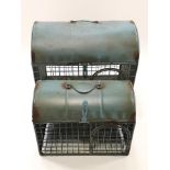 Two domed animal cages, each with swing handle, the top opening with a side door,