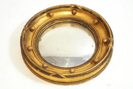 A 19th century convex gilt wood circular wall mirror,