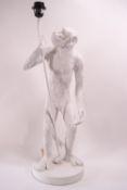 A white composite table lamp, supported by a langar monkey, 67cm high,