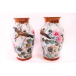 A pair of Japanese porcelain vases, painted with a bird in flight and flowers,