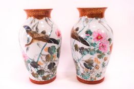 A pair of Japanese porcelain vases, painted with a bird in flight and flowers,