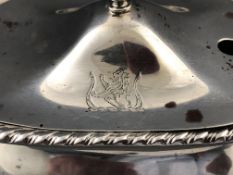 A silver rectangular mustard pot with domed lid topped with an urn over a bellied body