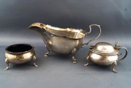 A silver plain form bellied salt with a matching domed lidded mustard,