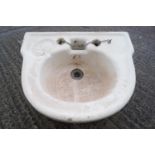 A glazed stoneware wash hand basin of half round form, set with an indented soap reserve,