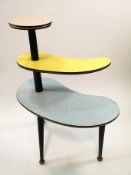 A formica three tier occasional table on turned legs,