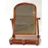 A 19th century mahogany swing dressing mirror with arched top frame on two S scroll brackets
