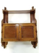 A Victorian mahogany two tier hanging wall shelf with two panelled doors overall 84cm high x 61cm