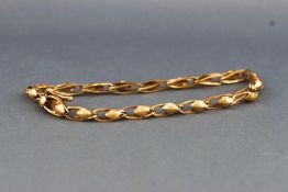 A yellow metal linked bracelet of textured and plain finish.