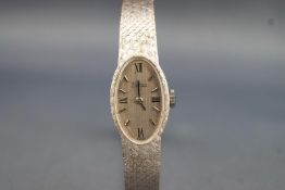 A white metal wristwatch by Zodiac. Oval case with silver dial and mixed markings.