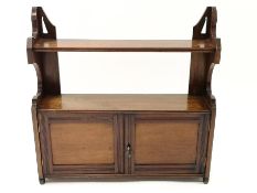 A 19th century mahogany hanging two tier wall shelf above two panelled doors,