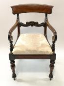 An early 19th century mahogany elbow chair with rail back, drop in seat,