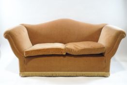 A camel back two seat sofa with apricot velvet covering,