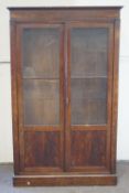 A nineteenth century mahogany display cabinet with adjustable shelves, on plinth base,