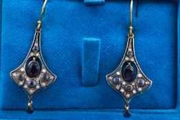 A yellow and white metal pair of drop earrings