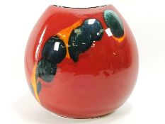 A Poole pottery vase of ovoid form, decorated with green yellow glaze on a red ground,