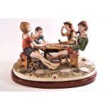 A Capodimonte figure, 'Cheats', in the form of four boys playing cards at an outdoor table,