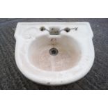 A glazed stoneware wash hand basin of half round form, set with an indented soap reserve,