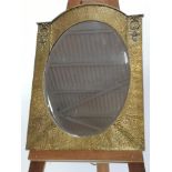 An Arts & Crafts polished brass arched top wall mirror, circa 1910,