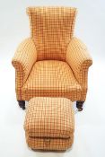 An upholstered club style chair with scrolled back and arms raised on turned hardwood castered legs