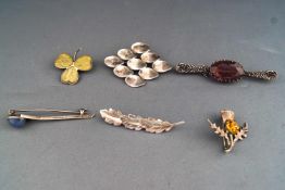 A collection of six white metal brooches of variable designs.
