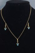 A yellow metal pendant and earring set.