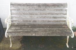 A Victorian style bench with white painted cast iron ends,