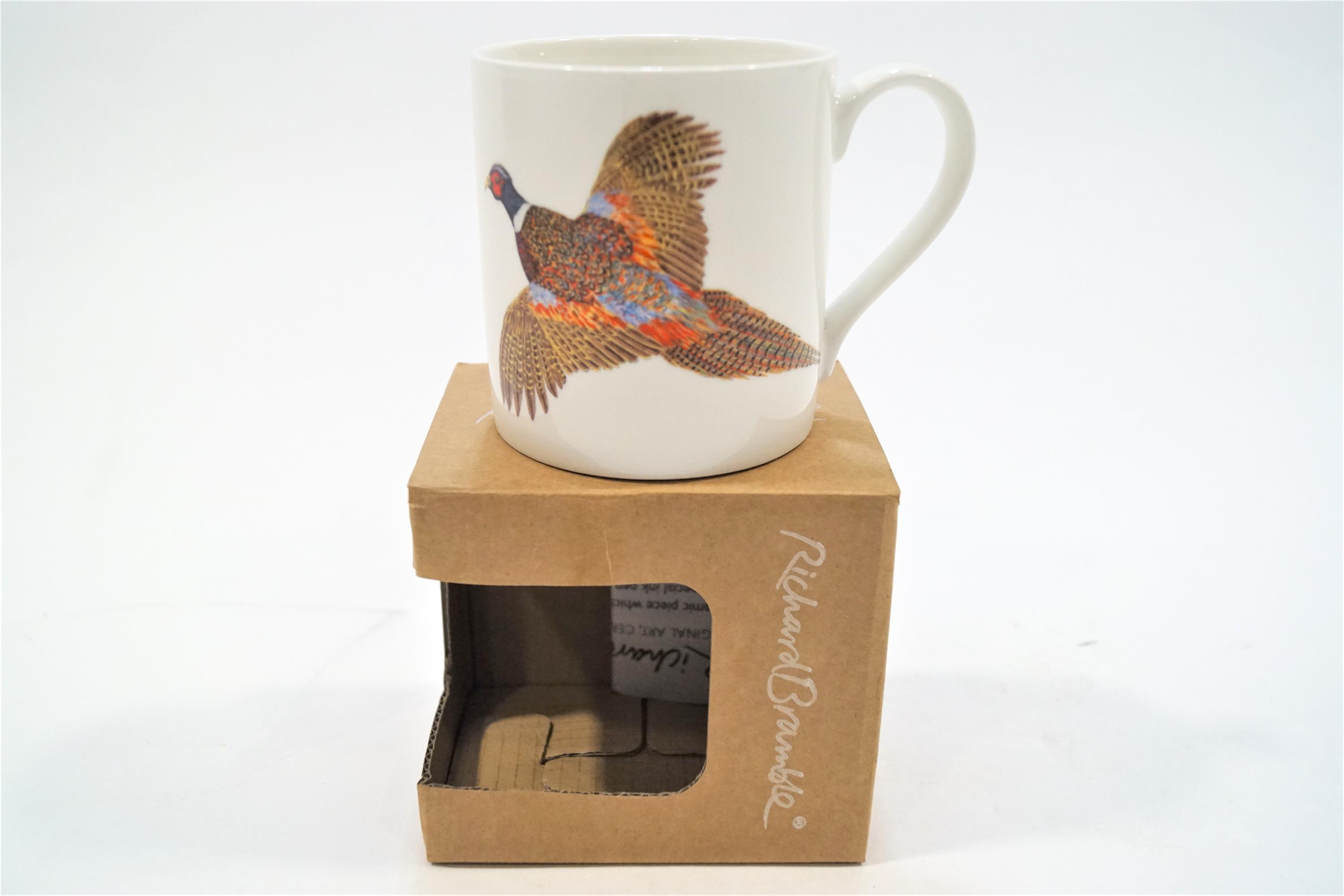 A boxed and signed Richard Bramble mug decorated with a pheasant in full flight,