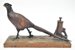 A cold painted spelter table cigar lighter in the form of a pheasant by a tree stump,