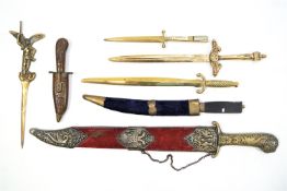 Four large sword style brass letter openers and three assorted knives