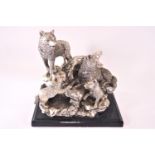 A silvered figural group of wolves, parents and two cubs on a rocky outcrop,