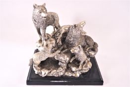 A silvered figural group of wolves, parents and two cubs on a rocky outcrop,