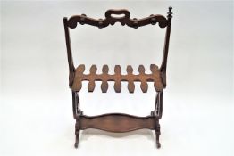 A mid 19th century mahogany boot stand with curved top rail with cut out grip over a cut our