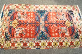 A rug with hooked medallions on a red field with one wide border 183cm x 104cm