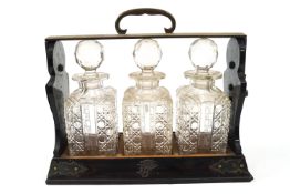 A Victorian coromandel and white metal mounted tantalus containing three cut glass decanters,
