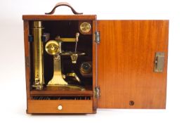 A wooden cased 19th Century brass microscope in mahogany fitted case with a drawer containing