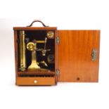 A wooden cased 19th Century brass microscope in mahogany fitted case with a drawer containing