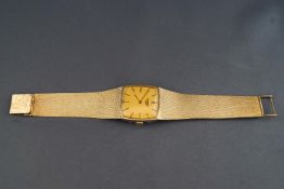 A yellow metal wristwatch by Longines. Cushion square dial with gold backing and baton markings.