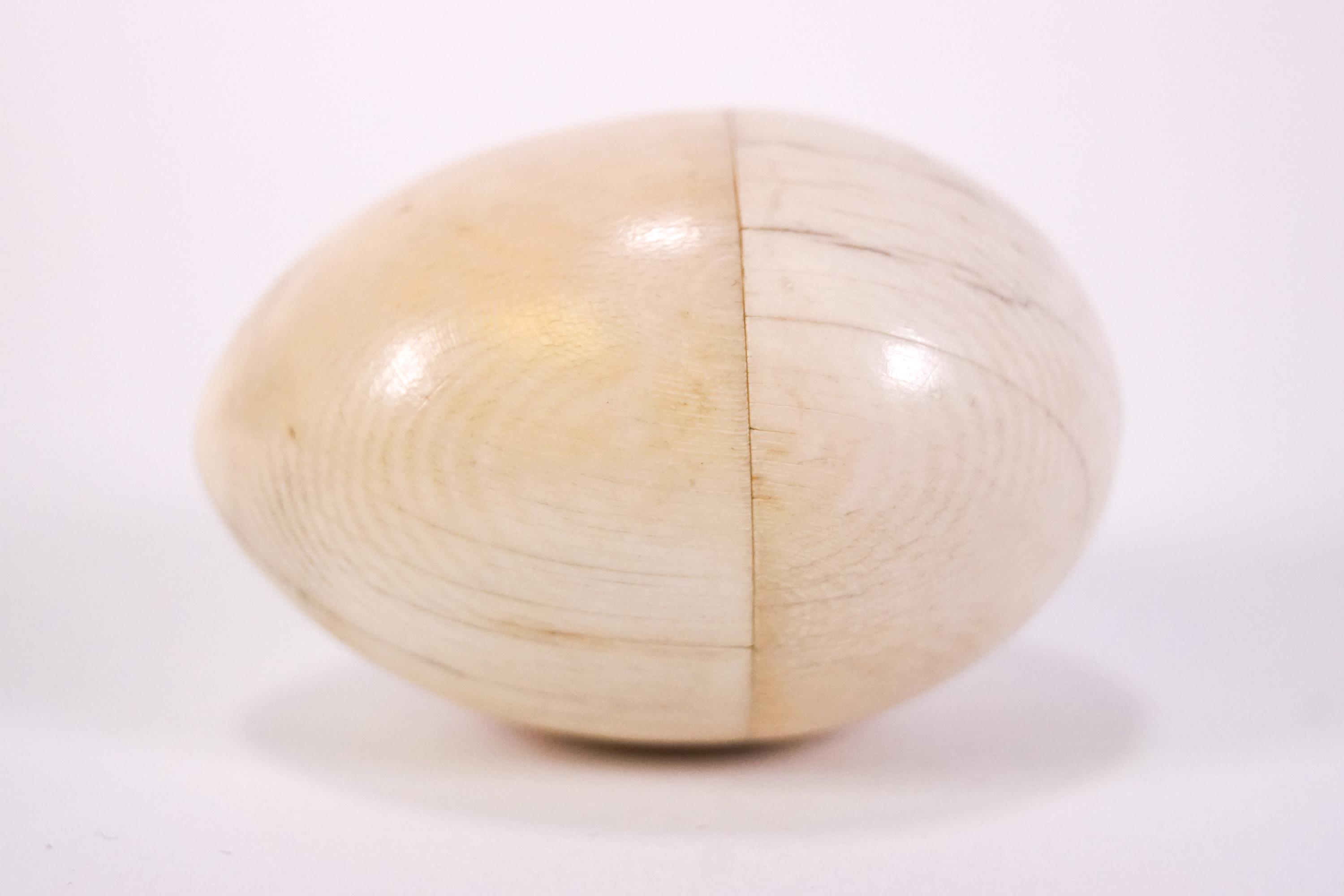 A 19th century turned ivory egg shaped thimble case with a white metal thimble, - Image 2 of 3