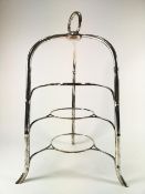 A plated cake plate stand with three bamboo form legs joining to a button top with a strap handle,