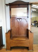 A late 19th/early 20th century oak Arts and Crafts hall stand/seat with curved pediment cresting