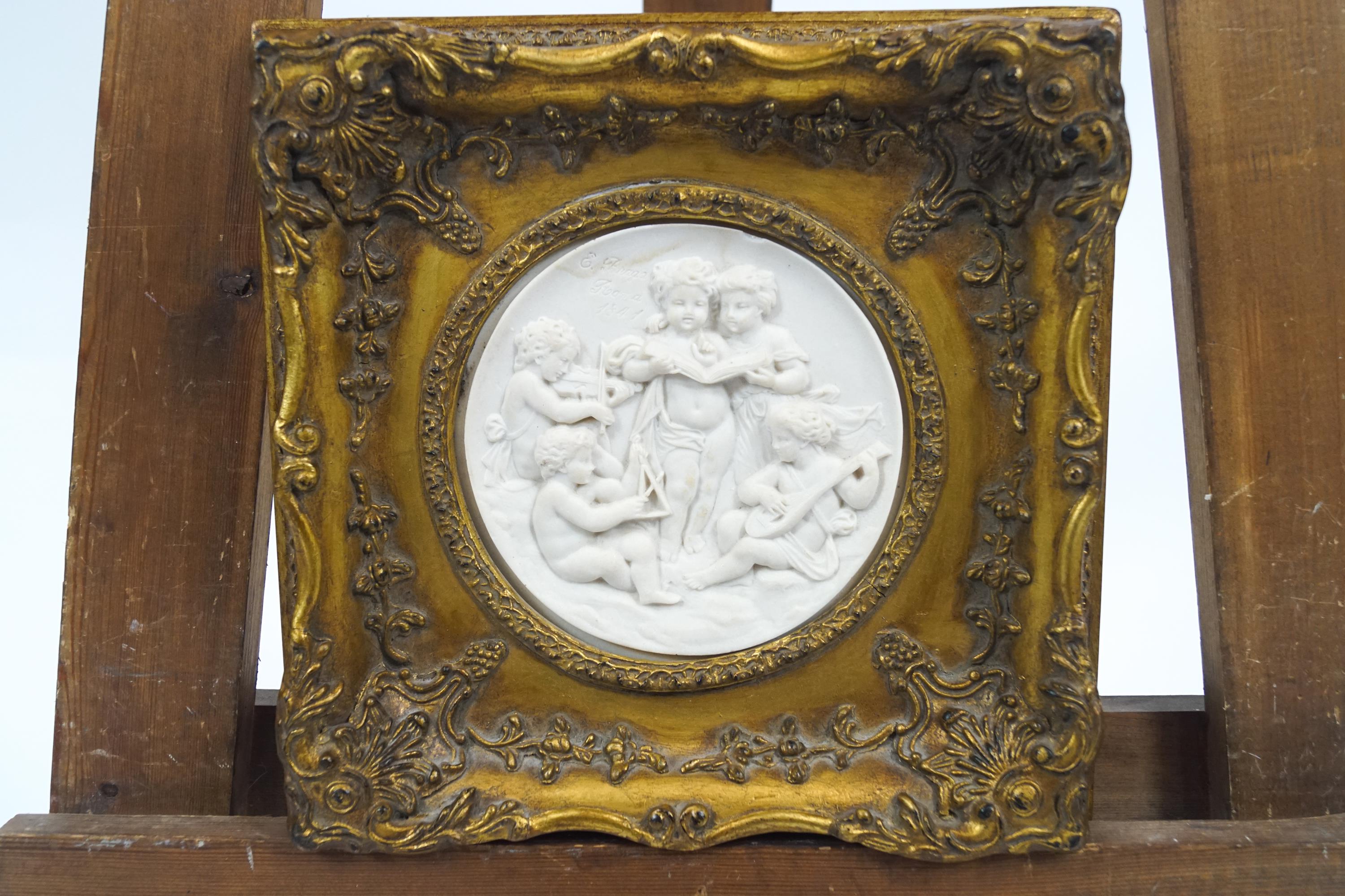 A gilt framed composition tondo of putti musicians,