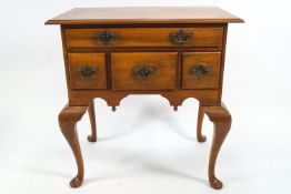 A George III style low boy with one long above three short drawers on cabriole legs,