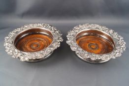 A pair of Sheffield plate style decanter coasters with cast and applied fruiting vine borders